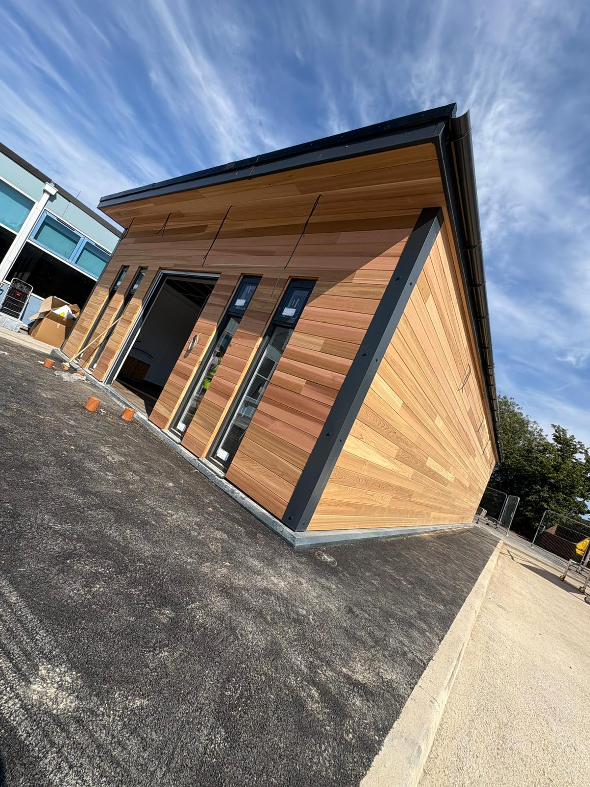 Angular cedar-clad timber building with black trim detailing