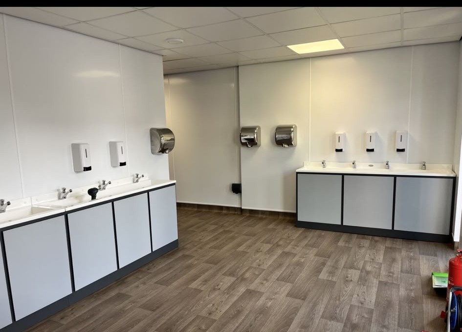 Finished commercial washroom with vanity units and hand dryers